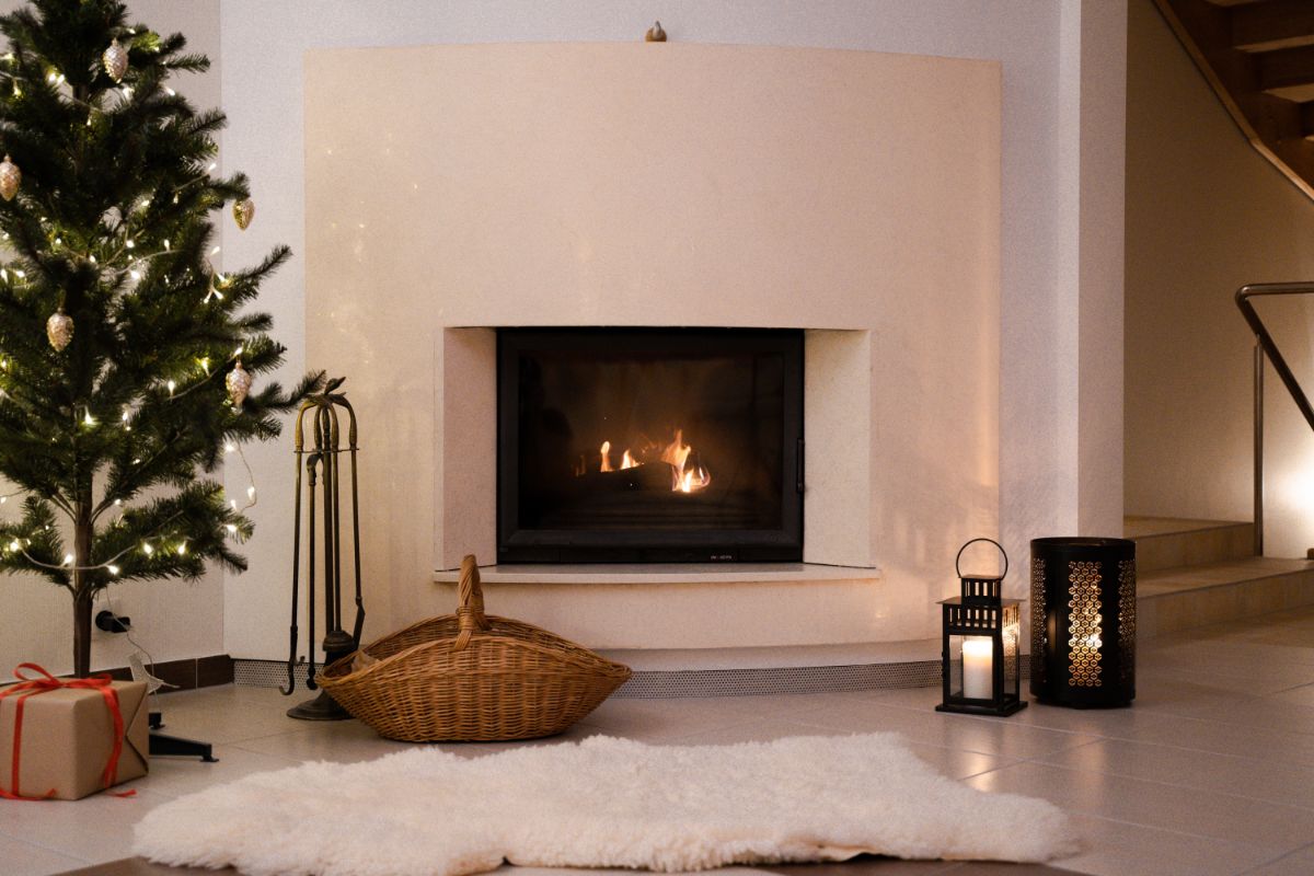 fireplace with white wall and christmas tree and candles
