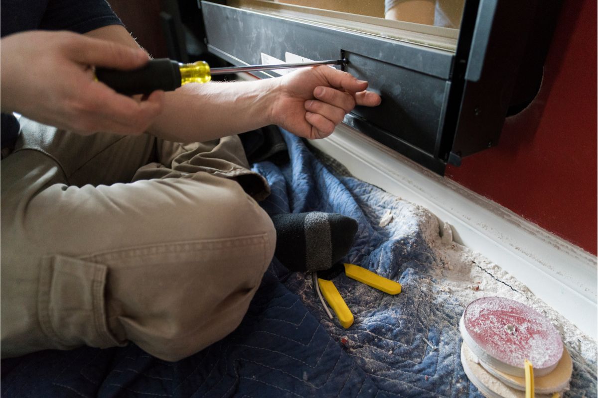 man installing an electric fireplace