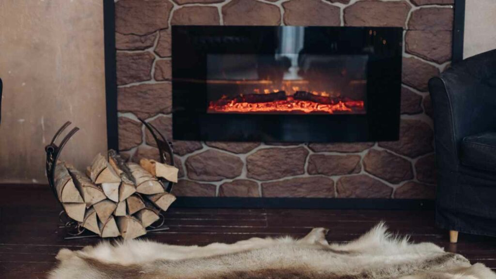 Wall mounted electric fireplace with rug and wood stack in front.