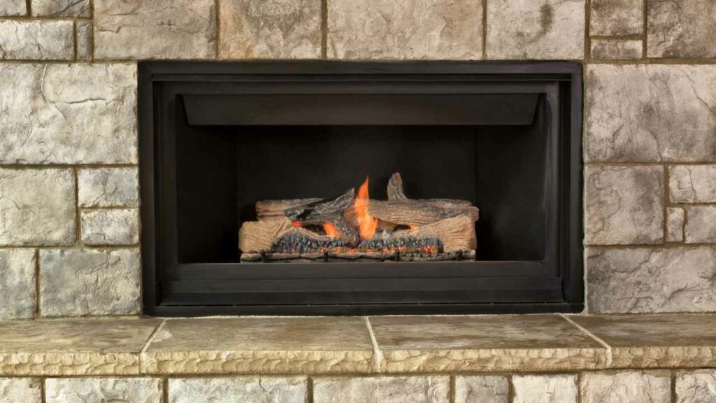 Natural Gas fireplace. Stone surround and hearth. fire burning.