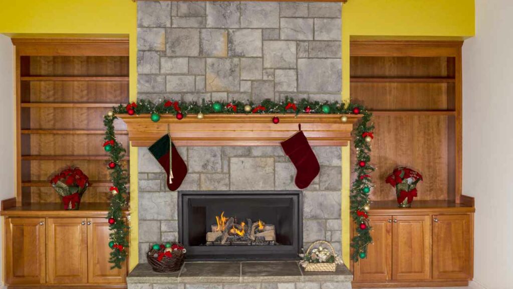 Modern gas fireplace. Stone fireplace surround. Wood mantel. Christmas decorations. Wood shelving each side of the fireplace.
