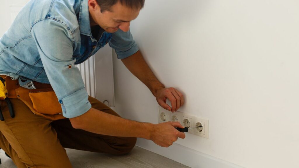 power outlet, man working on changing it.