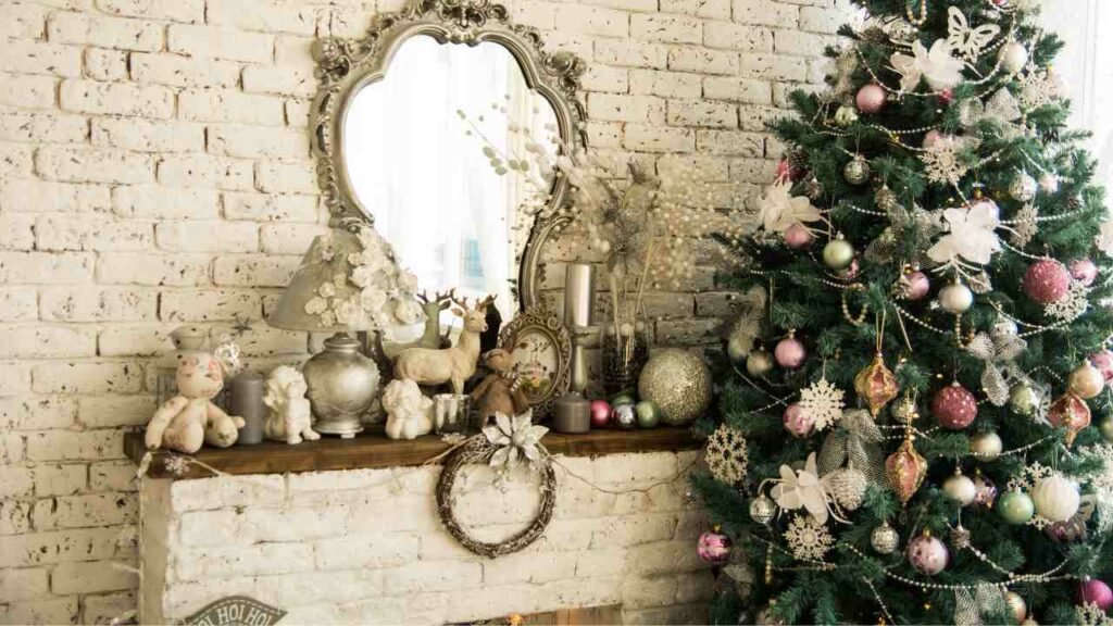 Thin wood mantel. Christas tree to the side and decorations on the mantel. Mirror above the mantel. White washed brick wall behind.