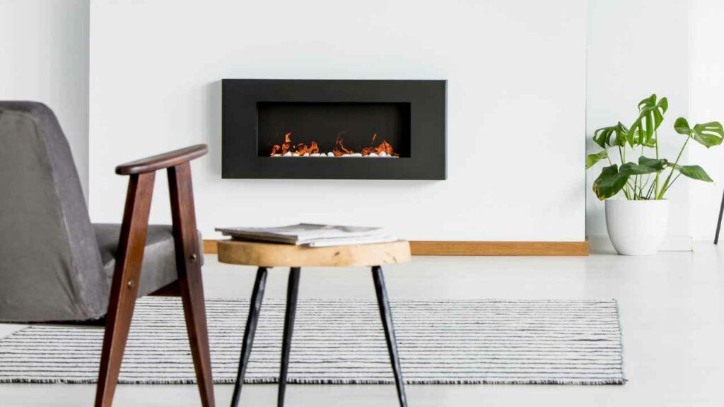 Wall hang black water vapor fireplace. off white wall. chair and side tabl;e in front of the fireplace.