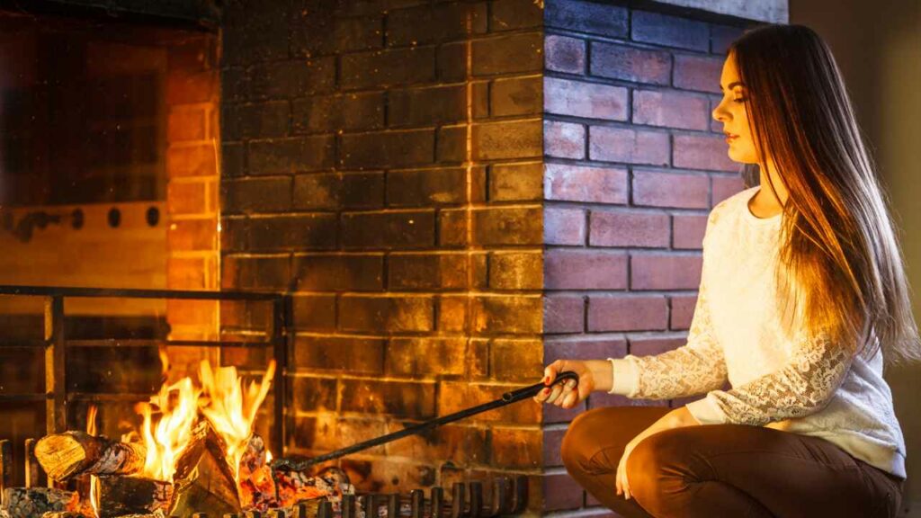 Red brick fireplace. wood burning. Woman using poker stick.