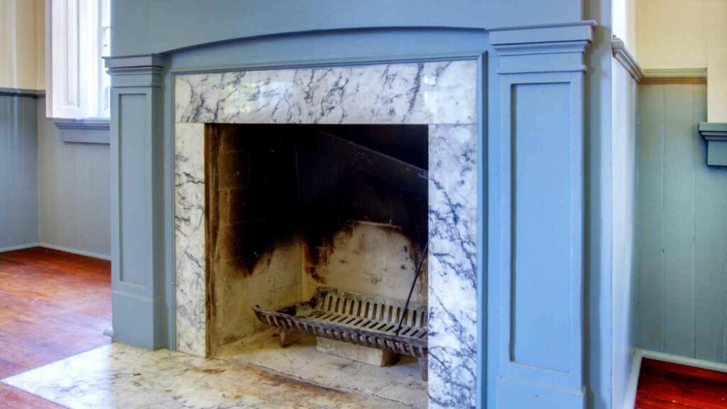 Blue marble fireplace. Wood burning, no flame burning. Blue fireplace surround. marble hearth. Wood flooring.