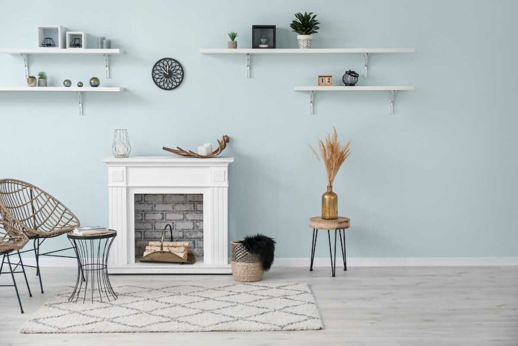 White washed fireplace with shelving above and small table to the side