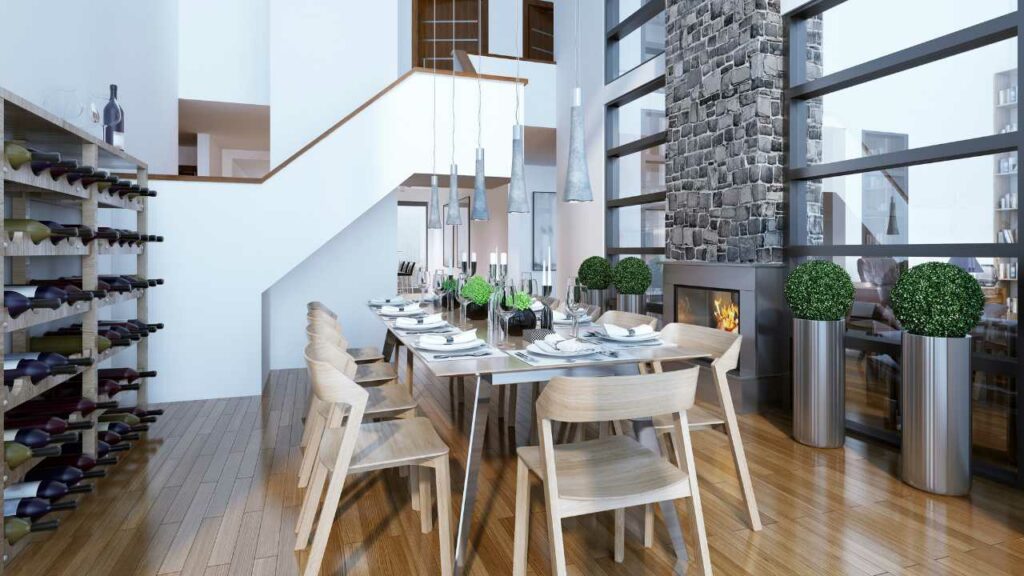 Fireplace next to a set dining table. Large wine rack to the side and wood flooring. Lights hanging down from the ceiling.