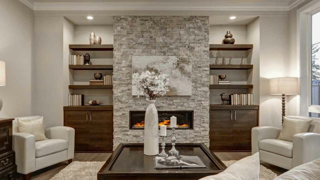 Gas fireplace. Stone fireplace surround in light grey. Alcoves either side. Book shelves in the alcove.