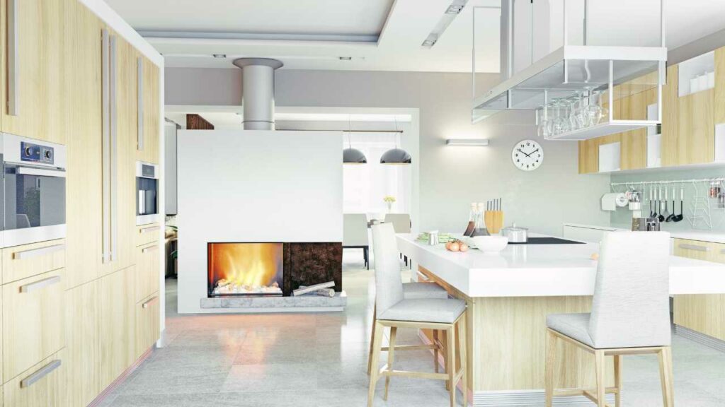 Modern kitchen with the fireplace as the focal point. White counter tops and light brown kitchen units.