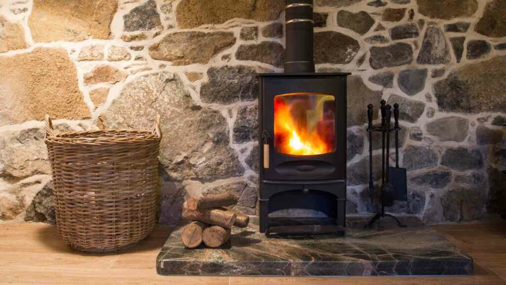 Stone fireplace surround. Wood burning fireplace. Wood stack and basket to one sie. Fireplace tools the either side. Small marble hearth.