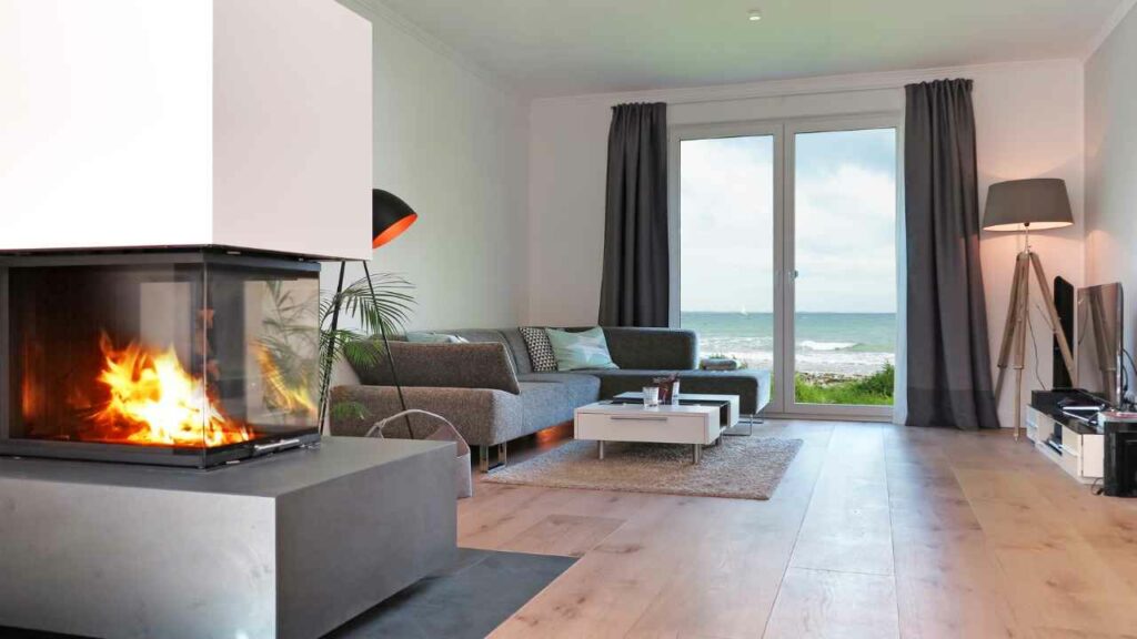 Beach House fireplace. Seaview. Wood flooring, grey sofa.