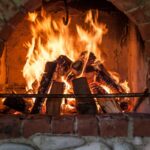 red brick fireplace, wood burning brightly.