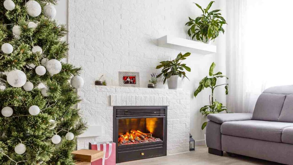 whitewashed brick walls and fireplace. christams tree to one side, sofa the other side. gas fireplace burning. plants.