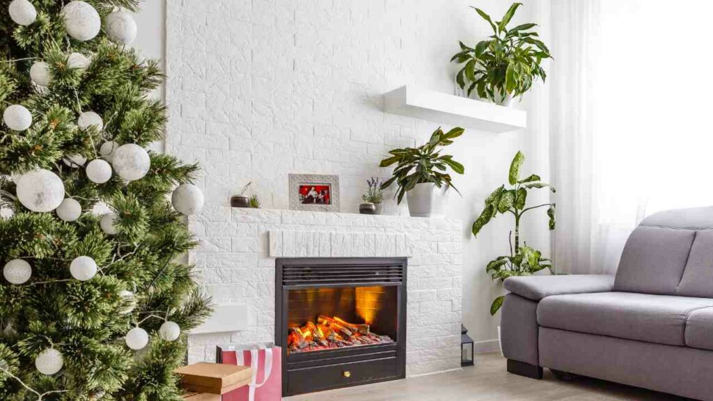 Electric fireplace with white brick surround. Boho style with plants next to the fireplace and above on the mantel.