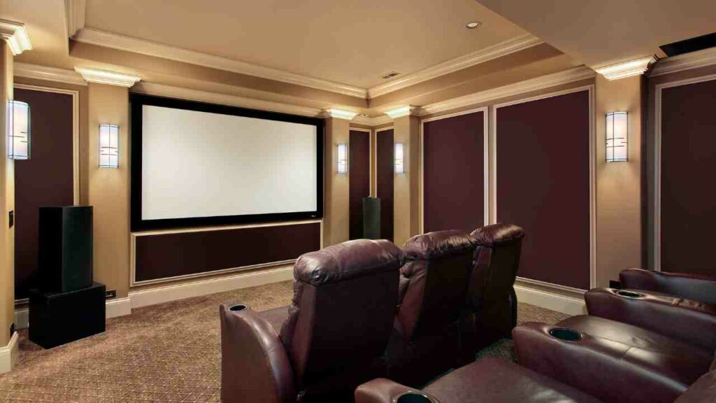 Home theatre with electric firplace below. Chairs in front of very large TV.