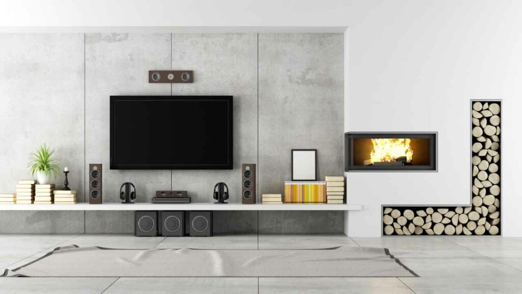 Modern fireplace with TV and Hi Fi Centre. Wood store set into the wall. Concrete wall.