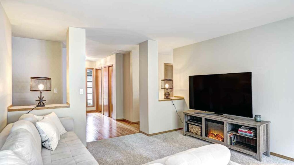 Electric fireplace, built into a TV entertainment centre. Sofa in front of the TV. large room.