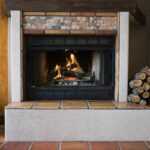 wood burninf fireplace, tiled surround and hearth. wood stock to one side.