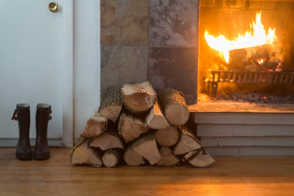 wood stacked in front of a wood burning fireplace.