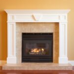 gas fireplace with tiled surround and orange colored walls. tiled hearth and wood flooring.