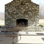 outdoor stone fireplace, seating with benches.