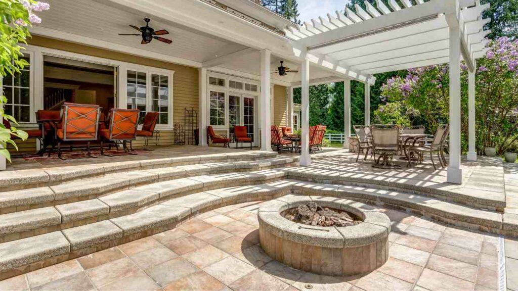 Circular stone fire pit. Next to a gazebo. Stone pave