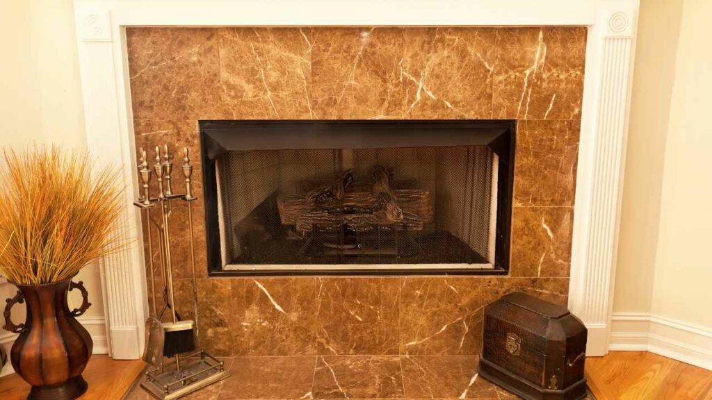 brown fireplace tiles and fireplace hearth. fireplace tools to one side.