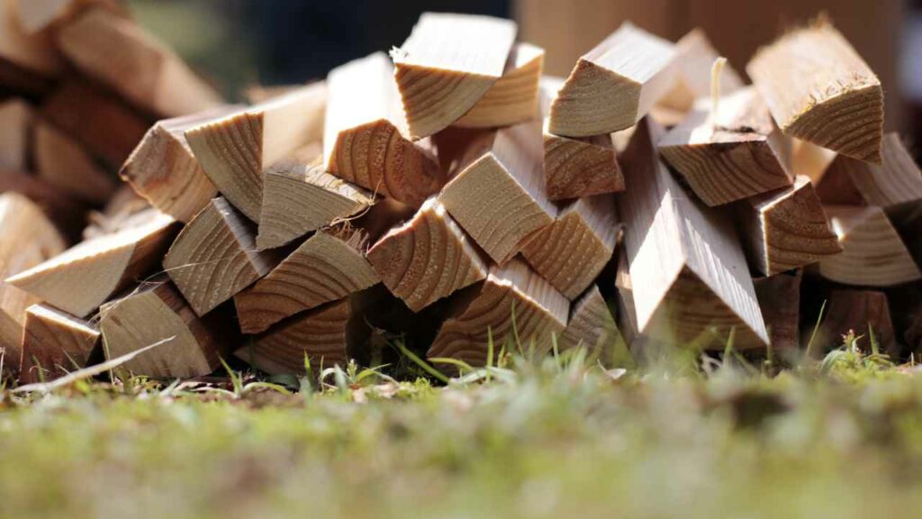 firewood kindling stacked. ready to use in a wood burning fireplace or fire pit. outside on grass.
