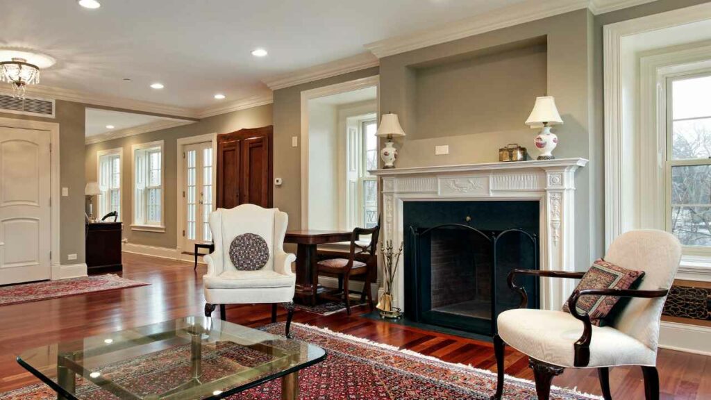 Fireplace with two lamps creating lighting on mantel. Fireplace guard. Stylish traditional room.