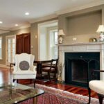 Fireplace with two lamps creating lighting on mantel. Fireplace guard. Stylish traditional room.