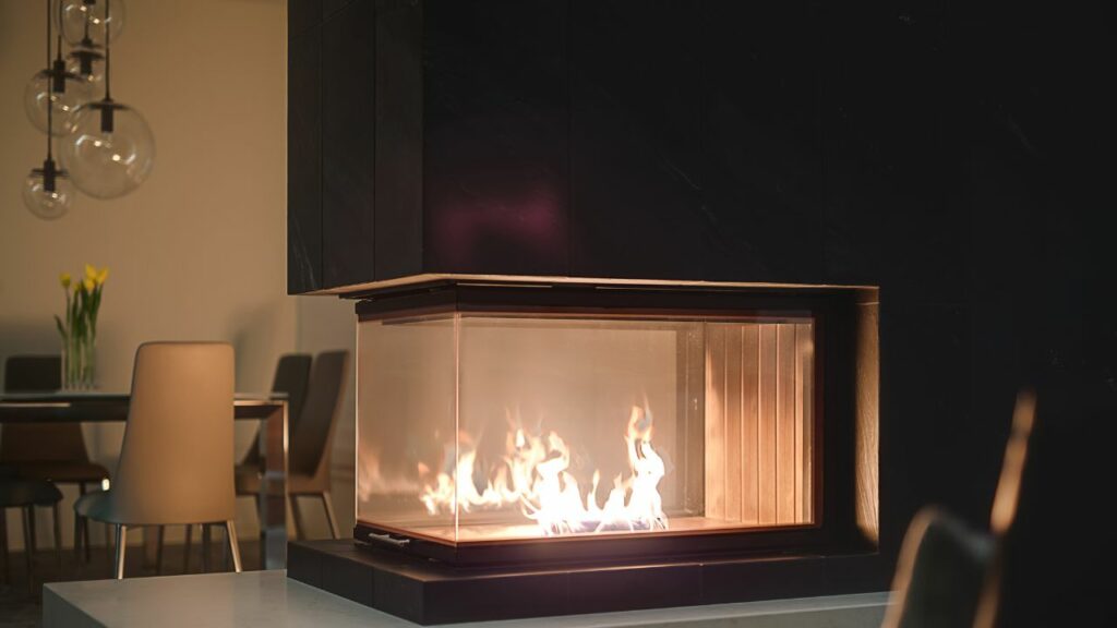 Modern three sided fireplace. Next to dining room creating cozy atmosphere.