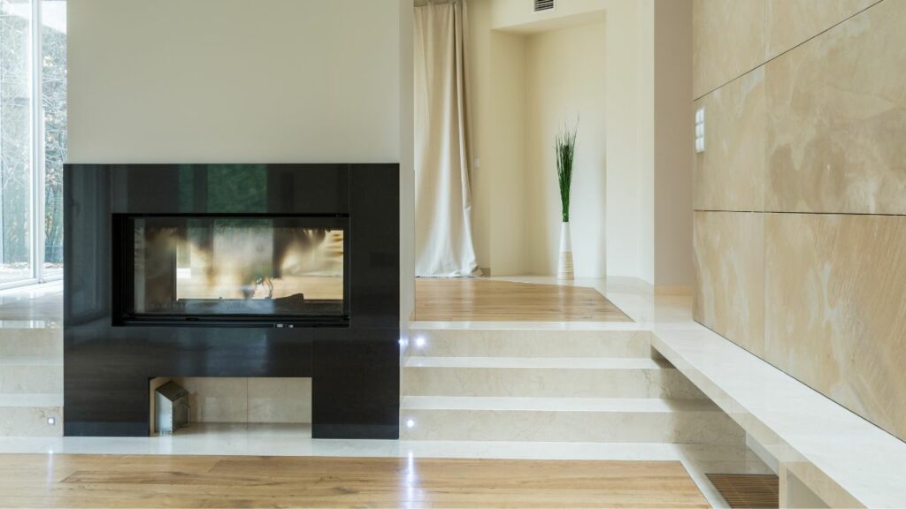 Modern fireplace. Black Surround. Wood Floors. Lots of space around.