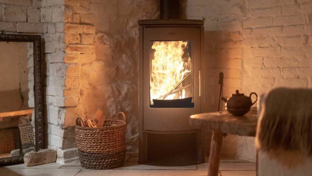 Fireplace nook with white washed walls. Metal stove. Mirror on the floor. Corner fireplace.