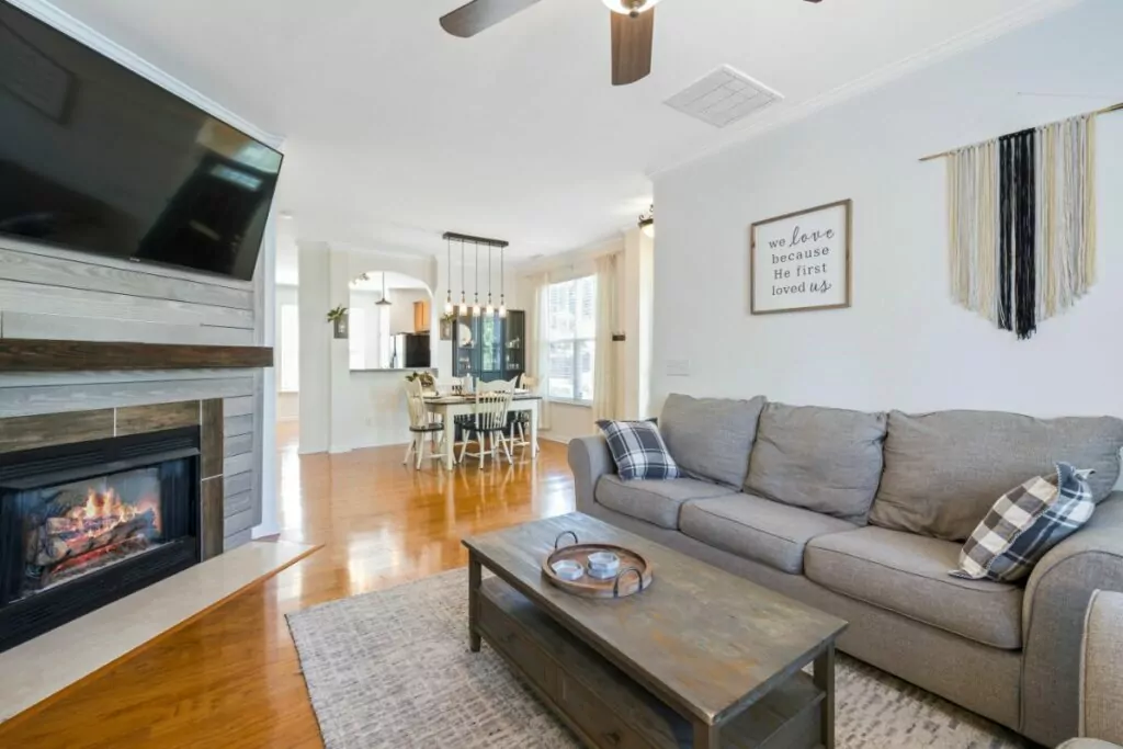 electric fireplace with modern stone wall with TV above and sofa and table