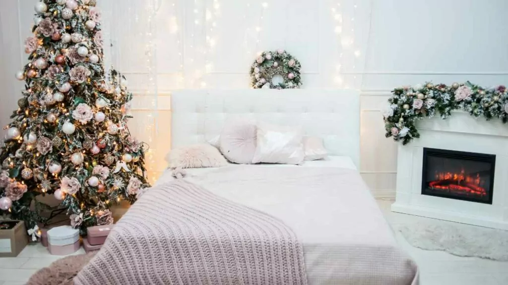 Electric fireplace insert next to bed. Christmas tree and decorations.