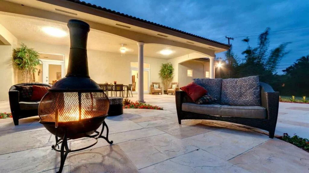 Outdoor cast iron fireplace, wood burning. Safa nearby. At night.