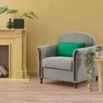 Empty fireplace with wood displayed instead of a fireplace yellow walls and lounge chair