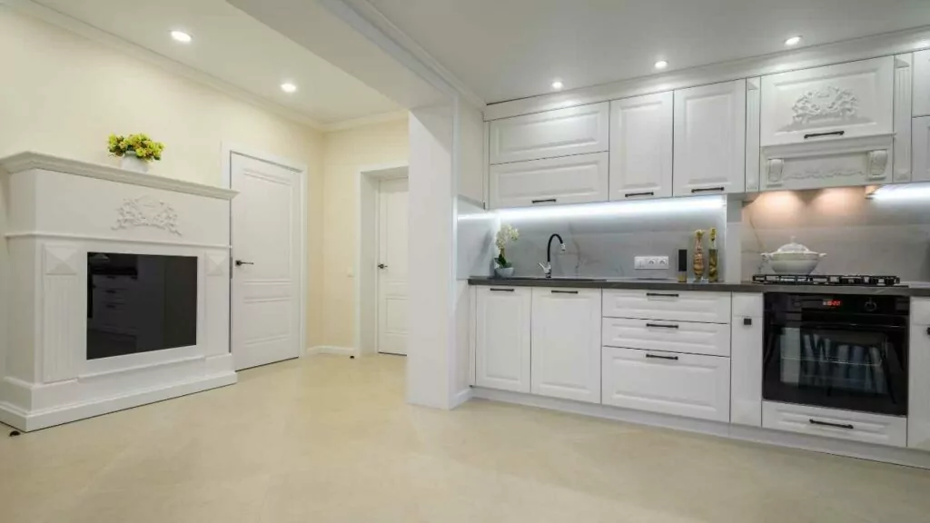 Electric fireplace in a kitchen. Modern kitchen with white units.