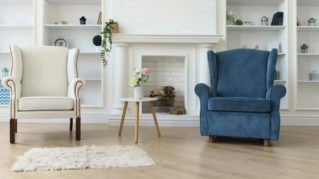 Boho fireplace with accent sheves. Empty fireplace with white washed brick. Two lounge chairs either side adn small rug in front.
