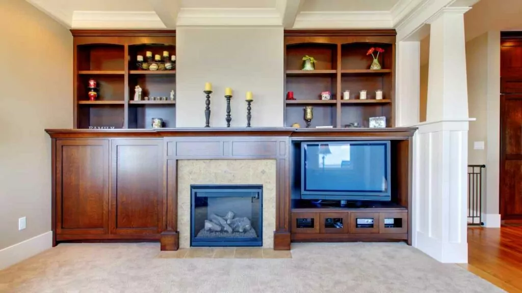 Electric fireplace in TV centre. Shelves above. Wood surround.