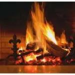 logs burning on a grate. brick fireplace.